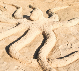 Octopus made of sand on the beach.