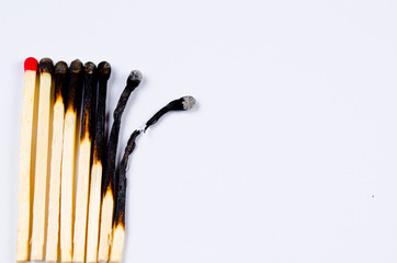 matches in different stages of burning on white