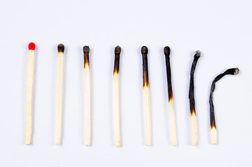 matches in different stages of burning on white - obrazy, fototapety, plakaty