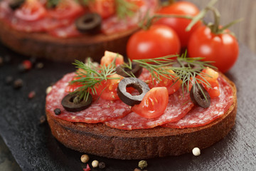 open rye sandwich with salami and vegetables