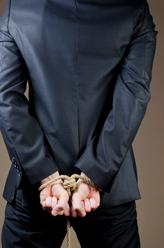 man in suit with tied hands