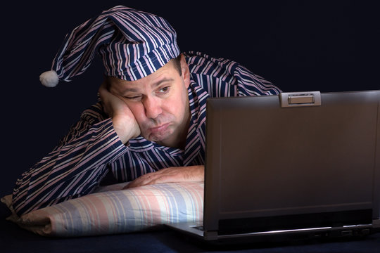 Unhappy Man With Computer In Bed