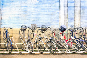 Obraz premium Multicolored vintage bicycles in metal rack in Tokyo city