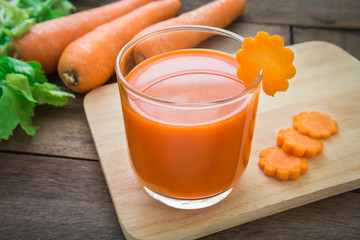 Fresh carrot juice on wooden plate