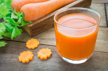 Fresh carrot juice on wooden table