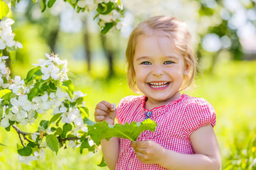 Happy little girl in spring sunny park