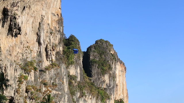 man does parachute jump from cliff at the background of hills