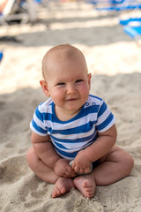 Little baby boy sitting on the sand
