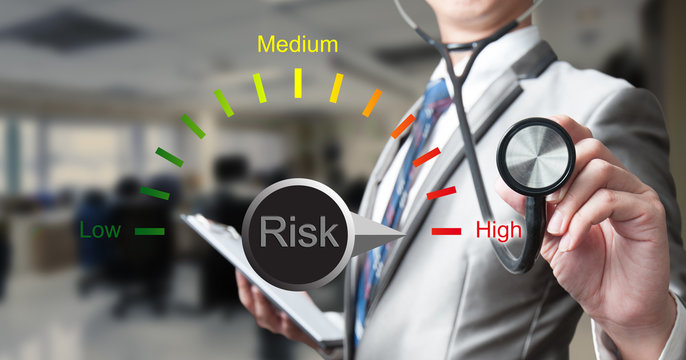 Business man with stethoscope examining with risk bar
