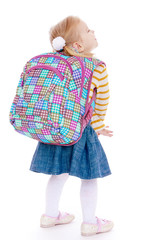 cheerful schoolgirl blonde standing with his back to the camera