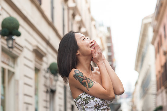 Young asian woman smiling using mobile phone spring urban