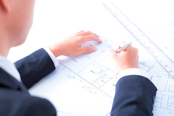 Hands of civil engineer correcting a blueprint