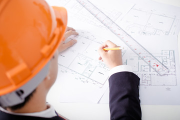 Hands of civil engineer correcting a blueprint