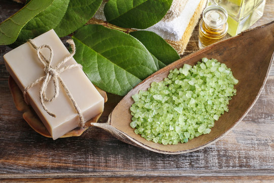 Green sea salt and bar of natural handmade soap on wooden table