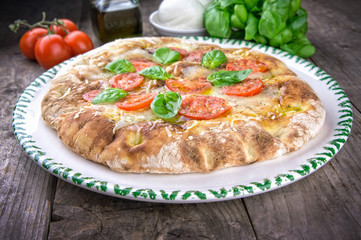 Focaccia pizza with fresh tomatoes on wooden table