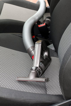 Saugeraufsatz mit Schlauch liegt auf Autositz