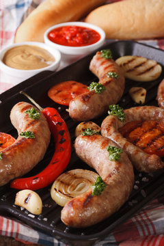 grilled sausage with vegetables and buns, sauce. Vertical