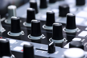 Fader and buttons of DJ mixer controller in nightclub