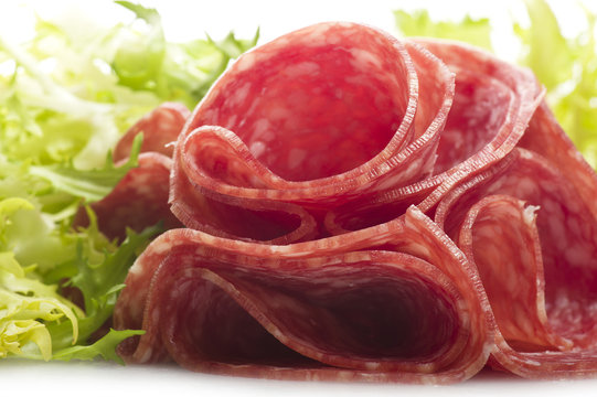 Salami sliced and bread with lattuce on white