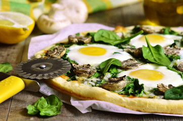Pizza with spinach,mushrooms and fried eggs.