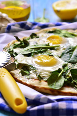 Pizza with spinach and fried eggs.