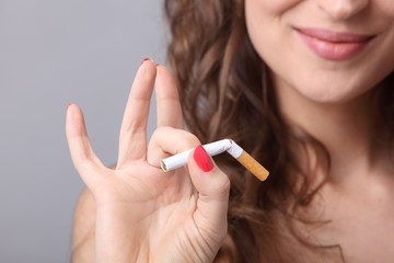Frau hält durchgebrochene Zigarette