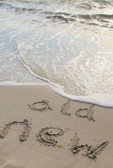 Die Worte „old“ and „new“ in den Sand gemalt