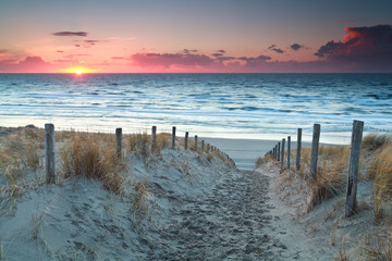 chemin de sable vers la plage de la mer du Nord avant le coucher du soleil