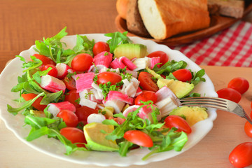 Mixed vegetable salad with crab sticks and avocado