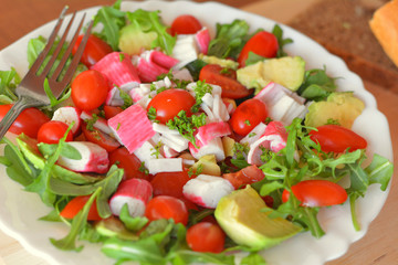 Mixed vegetable salad with crab sticks and avocado