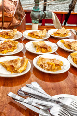 Pie served on a sailboat at sea. Slices on plates on wood deck.