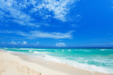 Fototapeta na wymiar footsteps on white sand and beautiful waves Cancun