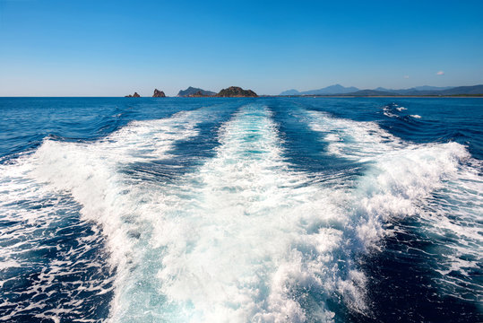 Fototapeta Waves on blue sea behind the boat