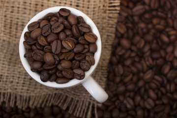 Чашка зерен кофе на мешковине