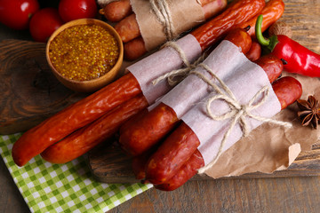 Assortment of thin sausages, mustard in bowl and spices