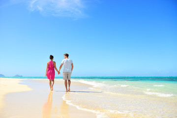 Fototapeta na wymiar Beach couple holding hands walking on honeymoon
