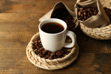 Cup of coffee with beans on rustic wooden background