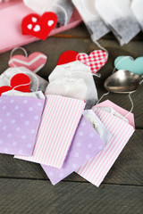 Heart shaped teabag tags on wooden background