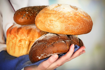 Armful of freshly bread in female hands