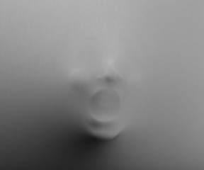 Screaming human face pressing through fabric as horror