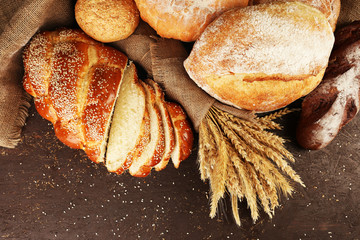 Different bread with ears on wooden background