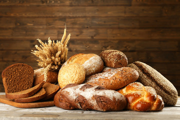 Different bread with ears on wooden background