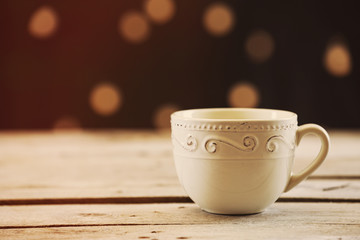 Cup of coffee on table on brown background