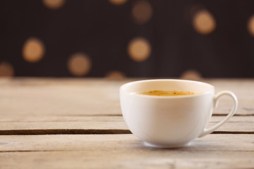 Cup of coffee on table on brown background