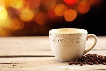 Cup of coffee on table on brown background