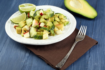Salad with apple and avocado in bowl on table close up