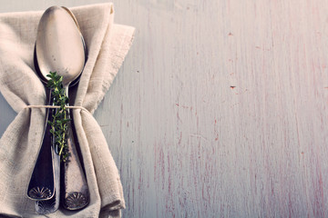 Vintage spoons and thyme on a napkin