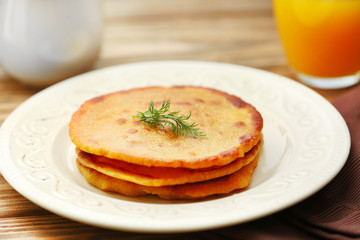 Stack of corn tortillas with stuffing and glass of juice