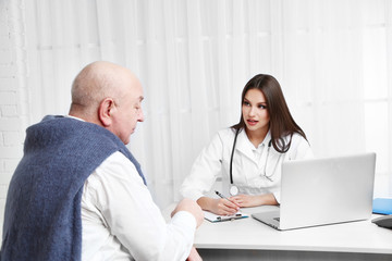 Fototapeta premium Young female doctor receiving patient in her office