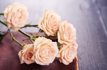 Roses with vintage book on wooden table background